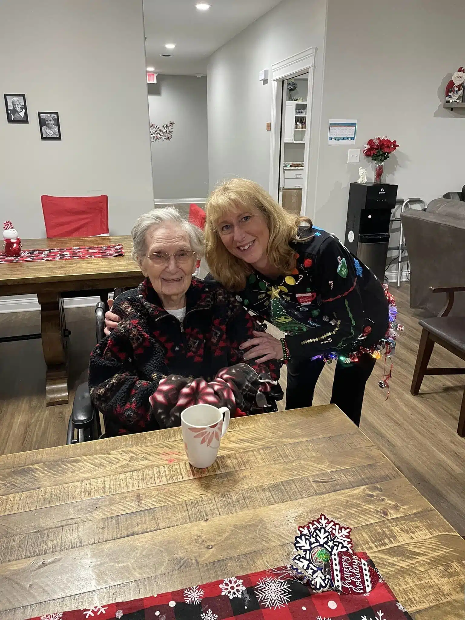 Resident smiling beside holiday decorations and a Christmas tree during a retirement home celebration