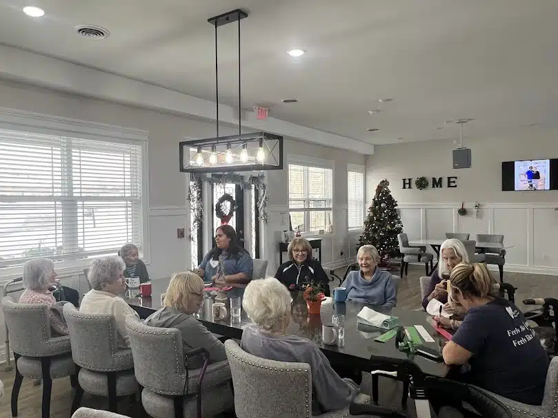Seniors and caregivers gathered around a table during a group activity at Two Hearts Home for Seniors in Indiana.